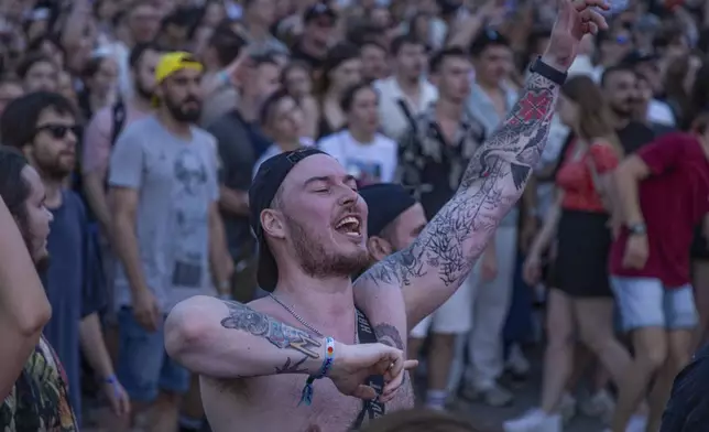 People enjoy a concert at the Atlas Festival in Kyiv, Ukraine, Sunday, July 21, 2024. This year, Ukraine's largest music festival struck a different chord. Gone were the international headliners, the massive performance halls and the hundreds of thousands of visitors. (AP Photo/Anton Shtuka)