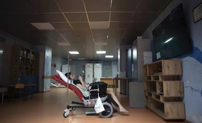 Denys Vasylenko, 11, plays on a video game console at the National Cancer Institute in Kyiv, Ukraine, Wednesday, July 10, 2024. Denys is one of 31 young patients battling cancer who were relocated to the hospital from Okhmatdyt Children’s Hospital after it was struck by a Russian missile this week. (AP Photo/Alex Babenko)