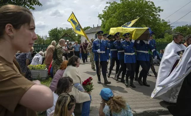 FILE - Soldiers carry the coffin of Andrii Konyaev, a member of the Azov unit, during his funeral in Fastiv, Ukraine, on Tuesday, May 23, 2023. He and more than 50 Ukrainians died in the July 29, 2022, explosions at Olenivka, a Russia-controlled prison camp in eastern Ukraine. (AP Photo/Evgeniy Maloletka, File)