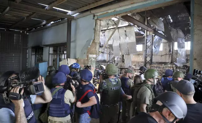 FILE - Journalists visit the destroyed barracks at the Russian-controlled Olenivka prison holding Ukrainian POWs in eastern Ukraine, on Aug. 10, 2022. Russia blamed Ukraine at the time but interviews with survivors witnesses and families of the missing as well as an internal U.N. analysis pointed to Russia as the culprit two years later. (AP Photo/File)3