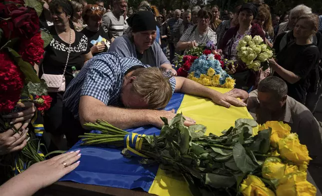 FILE - Leonid Konyaev and Valentina Konyaeva cry over the coffin of their son, Andrii Konyaev, a member of the Azov unit, during his funeral in Fastiv, Ukraine, on Tuesday, May 23, 2023. He and more than 50 Ukrainians died in the July 29, 2022, explosions at Olenivka, a Russia-controlled prison camp in eastern Ukraine. (AP Photo/Evgeniy Maloletka, File)