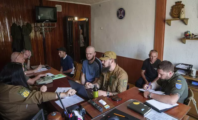 Prisoners speak to Ukrainian servicemen during an interview in a prison, in the Dnipropetrovsk region, Ukraine, Friday, June 21, 2024. Ukraine is expanding its military recruiting to cope with battlefield shortages more than two years into fighting Russia’s full-scale invasion. (AP Photo/Evgeniy Maloletka)