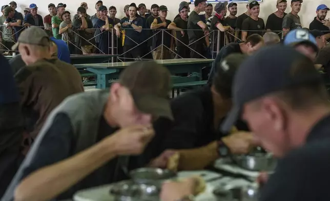 Prisoners wait in line for lunch in a prison, in the Dnipropetrovsk region, Ukraine, Friday, June 21, 2024. Ukraine is expanding its military recruiting to cope with battlefield shortages more than two years into fighting Russia’s full-scale invasion. (AP Photo/Evgeniy Maloletka)
