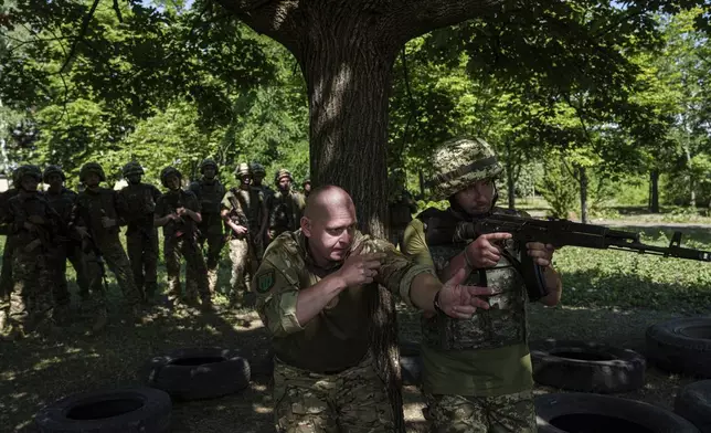 A Ukrainian military instructor of Arey Battalion trains a convict prisoner which join Ukrainian army to use a weapon at the polygon, in the Dnipropetrovsk region, Ukraine, Saturday, June 22, 2024. Ukraine is expanding its military recruiting to cope with battlefield shortages more than two years into fighting Russia’s full-scale invasion. (AP Photo/Evgeniy Maloletka)
