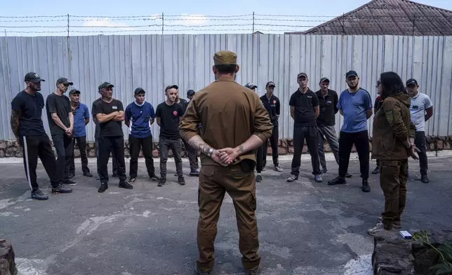 Prisoners listen to a Ukrainian sergeant of the Battalion Arey during an interview in a prison, in the Dnipropetrovsk region, Ukraine, Friday, June 21, 2024. Ukraine is expanding its military recruiting to cope with battlefield shortages more than two years into fighting Russia’s full-scale invasion. (AP Photo/Evgeniy Maloletka)