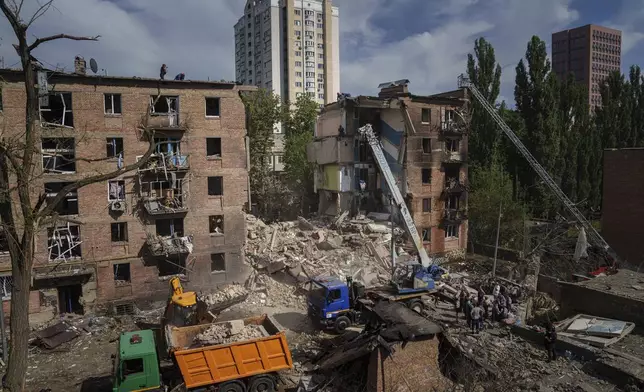 Rescuers clean up the rubble and search victims after Russian missile hit an apartment house in Kyiv, Ukraine, Monday, July 8, 2024. (AP Photo/Evgeniy Maloletka)