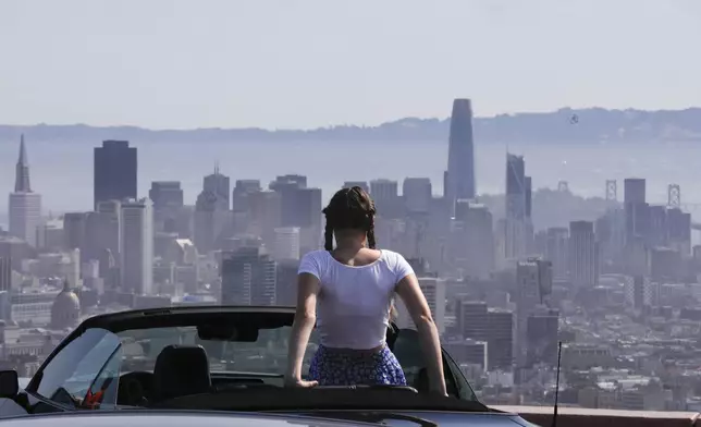 Lilou Guerra, 16, of France is dressed for sunny weather during a heat wave while she takes in the view of San Francisco, while visiting Twin Peaks with her parents on Wednesday, July 3, 2024. (Lea Suzuki/San Francisco Chronicle via AP)
