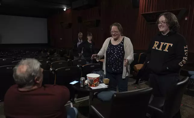 Wendy Clark, second from right, and her son Solomon Shemano, right, visit with Craig Mesure, left, as they leave the theatre after the 7 p.m. showing of Raising Arizona at the Littel Art Theatre on Thursday, May 16, 2024, in Yellow Springs, Ohio. When the Little Art Theatre set out to land a $100,000 grant to fund a stylish new marquee, the cozy arthouse theater had some talented help. Oscar-winning documentarian Steve Bognar lives in Yellow Springs, the bohemian Ohio town where the theater's a downtown fixture. (AP Photo/Carolyn Kaster)