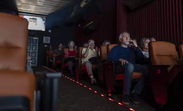 Moviegoers look to the screen during the 7 p.m. showing of Raising Arizona at the Littel Art Theatre on Thursday, May 16, 2024, in Yellow Springs, Ohio. When the Little Art Theatre set out to land a $100,000 grant to fund a stylish new marquee, the cozy arthouse theater had some talented help. Oscar-winning documentarian Steve Bognar lives in Yellow Springs, the bohemian Ohio town where the theater's a downtown fixture. (AP Photo/Carolyn Kaster)