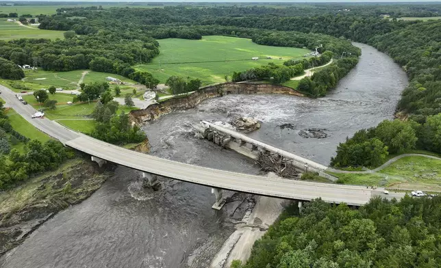 Floodwater continues to carve a channel around the Rapidan Dam, Thursday, June 27, 2024, near Mankato, Minn. Water breached the earthen abutment early Monday morning and rapidly eroded the west bank of the Blue Earth River. (AP Photo/Mark Vancleave)