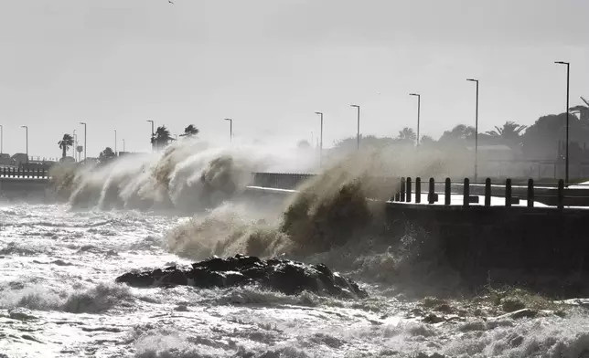 Waves break over Sea Point's promenade in Cape Town, South Africa, Monday, July 8, 2024. City authorities say nearly 1,000 homes in informal settlements around the city have been destroyed by gale-force winds, displacing around 4,000 people with multiple cold fronts expected until at least Friday. (AP Photo/Nardus Engelbrecht)