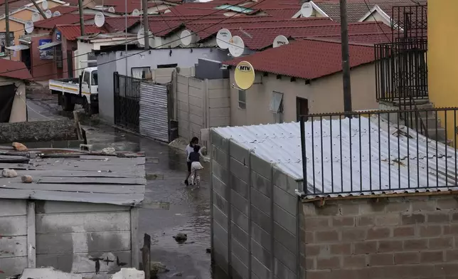 Water flows through Khayelitsha, Cape Town, South Africa, Thursday July 11, 2024. The South African city of Cape Town and surrounding areas have been hit by more storms, ripping roofs off houses and causing widespread flooding. (AP Photo/Nardus Engelbrecht)