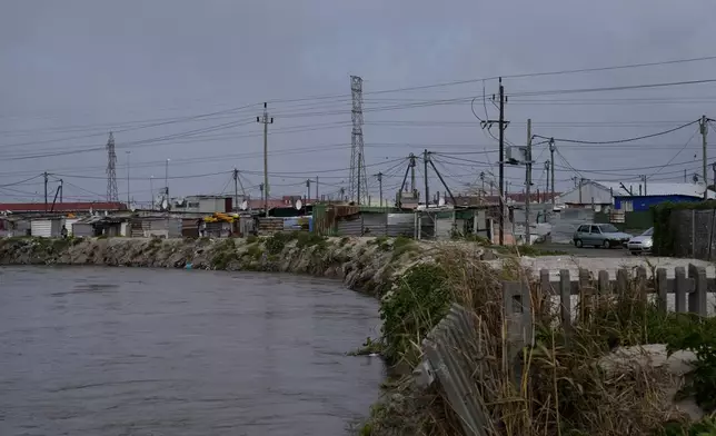 Water flows through Khayelitsha, Cape Town, South Africa, Thursday July 11, 2024. The South African city of Cape Town and surrounding areas have been hit by more storms, ripping roofs off houses and causing widespread flooding. (AP Photo/Nardus Engelbrecht)