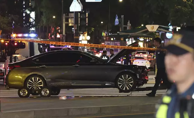 Police officers control a car accident scene near Seoul City Hall in downtown Seoul, South Korea, Monday, July 1, 2024. A car slammed into pedestrians in central Seoul on Monday night, killing nine people and injuring four others, officials said. (Seo Dae-yeon/Yonhap via AP)
