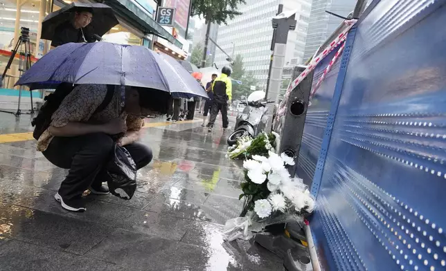 A man prays for victims at a car accident scene near Seoul City Hall in downtown Seoul, South Korea, Tuesday, July 2, 2024. A car hit several people Monday night, after reportedly going in the wrong direction and colliding with two other cars killing multiple people. The driver will be investigated on allegations of accidental homicide, police said Tuesday. (AP Photo/Ahn Young-joon)