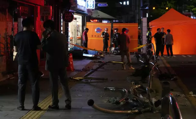 Police officers control a car accident scene near Seoul City Hall in downtown Seoul, South Korea, Monday, July 1, 2024. A car slammed into pedestrians in central Seoul on Monday night, killing nine people and injuring four others, officials said. (AP Photo/Ahn Young-joon)