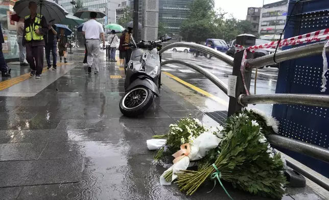 Flowers are placed at a car accident scene near Seoul City Hall in downtown Seoul, South Korea, Tuesday, July 2, 2024. A car hit several people Monday night, after reportedly going in the wrong direction and colliding with two other cars killing multiple people. The driver will be investigated on allegations of accidental homicide, police said Tuesday. (AP Photo/Ahn Young-joon)