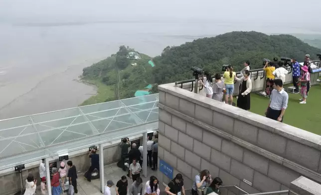 Visitors watch North Korean side from the Unification Observation Post in Paju, South Korea, near the border with North Korea, Friday, July 19, 2024. South Korea said Friday it has restarted blasting propaganda broadcasts into North Korea to retaliate against the North's latest round of trash-carrying balloon launches, a resumption of Cold War-style tactics that are raising animosities between the rivals. (AP Photo/Ahn Young-joon)