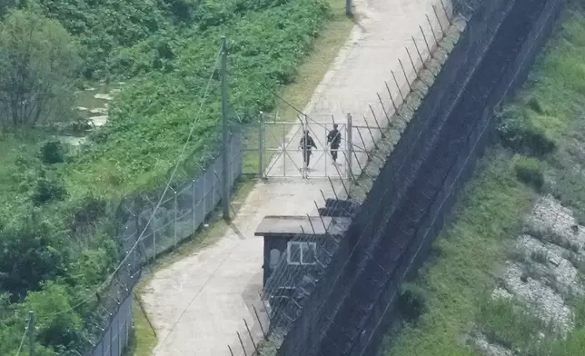 South Korean army soldiers patrol along the barbed-wire fence in Paju, South Korea, near the border with North Korea, Friday, July 19, 2024. South Korea said Friday it has restarted blasting propaganda broadcasts into North Korea to retaliate against the North's latest round of trash-carrying balloon launches, a resumption of Cold War-style tactics that are raising animosities between the rivals.(AP Photo/Ahn Young-joon)