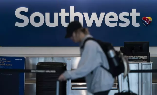 FILE - A traveler walks through the Southwest Airlines ticketing counter area at the Los Angeles International Airport in Los Angeles, April 18, 2023. Federal officials are investigating an incident on July 14, 2024, in which a Southwest jet flew as low as 150 feet (45 meters) over water while it was still several miles from its intended landing spot at the airport in Tampa, Fla. (AP Photo/Jae C. Hong, File)