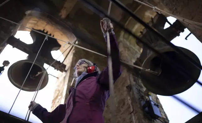 Roser Reixach, a student of the Vall d'en Bas School of Bell Ringers, performs playing a bronze bell at the church bell tower of the12th-century Sant Romà church, at the tiny village of Joanetes, about two hours north of Barcelona, Spain, Saturday, July 29, 2024. A school set up to revive the manual ringing of church bells has graduated its first class of 18 students after learning their ringing skills. (AP Photo/Emilio Morenatti)