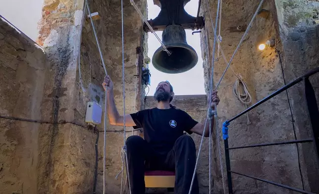 +++ON HOLD++++ Sitting in a chair with ropes looped around both feet and hands, Joan Carles Osuna, a student of the Vall d'en Bas School of Bell Ringers, performs playing all four bronze bells at the church bell tower of the12th-century Sant Romà church, at the village of Joanetes, about two hours north of Barcelona, Spain, Saturday, July 29, 2024. A school set up to revive the manual ringing of church bells has graduated its first class of 18 students after learning their ringing skills. (AP Photo/Emilio Morenatti)