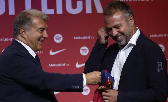 Barcelona's new coach Hansi Flick and Barcelona FC President, Joan Laporta, pose for a photo during an official presentation event of the new coach in Barcelona, Spain, Thursday, July 25, 2024. FC Barcelona and Hansi Flick have reached an agreement for the German to become men's first team football coach until 30 June 2026. (AP Photo/Joan Monfort)