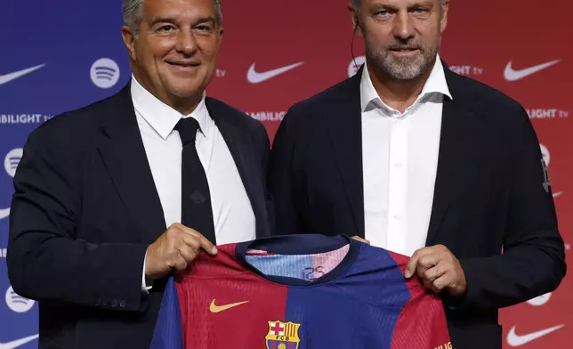 Barcelona's new coach Hansi Flick and Barcelona FC President, Joan Laporta, pose for a photo during an official presentation event of the new coach in Barcelona, Spain, Thursday, July 25, 2024. FC Barcelona and Hansi Flick have reached an agreement for the German to become men's first team football coach until 30 June 2026. (AP Photo/Joan Monfort)