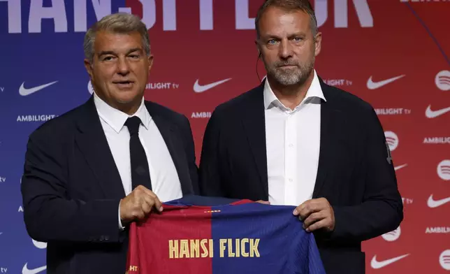 Barcelona's new coach Hansi Flick and Barcelona FC President, Joan Laporta, pose for a photo during an official presentation event of the new coach in Barcelona, Spain, Thursday, July 25, 2024. FC Barcelona and Hansi Flick have reached an agreement for the German to become men's first team football coach until 30 June 2026. (AP Photo/Joan Monfort)