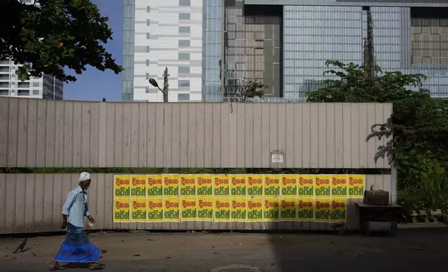 A Muslim man walks past a wall pasted with election propaganda of the main opposition candidate in the upcoming presidential election in Colombo, Sri Lanka, Friday, July 26, 2023. (AP Photo/Eranga Jayawardena)