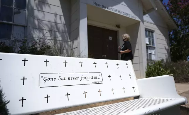 Karen Johns visits the First Baptist Church in Sutherland Springs, Texas, Tuesday, July 2, 2024, which is now a memorial to the 26 people who were killed by a gunman in 2017. The 100-year-old building has served as a memorial since the shooting, but now some want to raze the building. (AP Photo/Eric Gay)