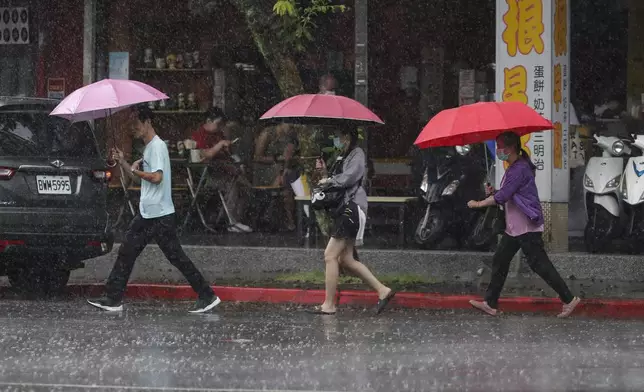 People walk in the rain as Typhoon Gaemi approaches in Taipei, Taiwan, Wednesday, July 24, 2024. (AP Photo/Chiang Ying-ying)