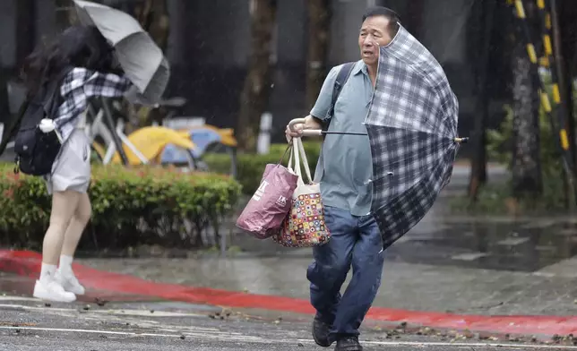 People walk in the rain as Typhoon Gaemi approaches in Taipei, Taiwan, Wednesday, July 24, 2024. (AP Photo/Chiang Ying-ying)