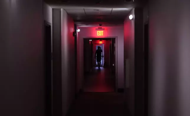 A hotel guest navigates the halls after power was lost due to Hurricane Beryl, Monday, July 8, 2024, in Bay City, Texas. (AP Photo/Eric Gay)