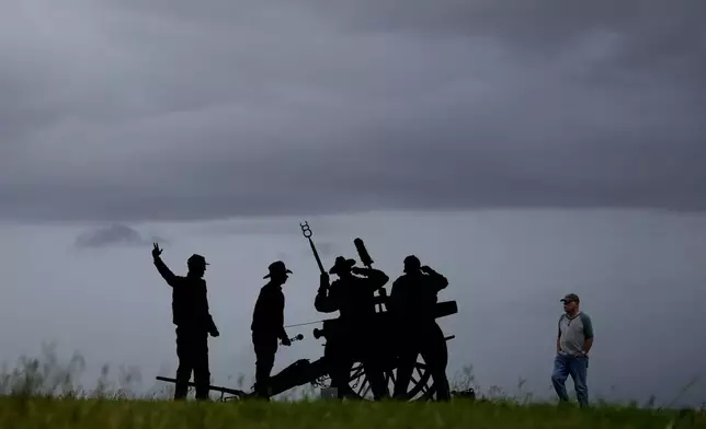 Leo Cardin walks past a Confederate Artillery Battery display as he watches storm clouds roll in ahead of Beryl, Sunday, July 7, 2024, in Port Lavaca, Texas. (AP Photo/Eric Gay)