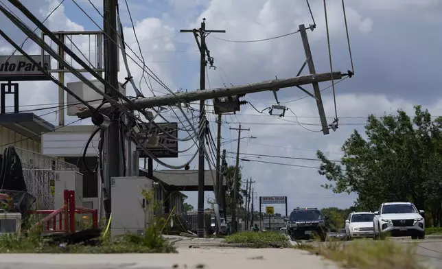 Traffic is directed around a downed power line in Houston, Tuesday, July 9, 2024. After Hurricane Beryl slammed into Texas, knocking out power to nearly 3 million homes and businesses it moved east and weakened to a tropical depression. (AP Photo/Eric Gay)