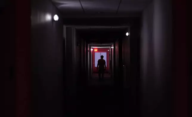 A hotel guest navigates the halls after power was lost due to Hurricane Beryl, Monday, July 8, 2024, in Bay City, Texas. (AP Photo/Eric Gay)