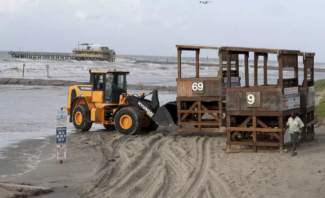 Workers with the Galveston Island Park Board of Trustees remove lifeguard towers from the beach near 57th Street in Galveston, Texas on Sunday, July 7, 2024, as Tropical Storm Beryl churns toward the Texas Coast. The storm is expected to make landfall near Matagorda Bay early Monday morning. (Jennifer Reynolds/The Galveston County Daily News via AP)