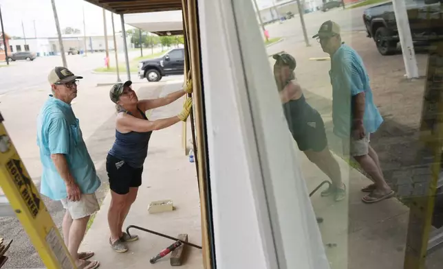 Sherry Cothron and Jimmy May board windows as they prepare for Hurricane Beryl's arrival, Sunday, July 7, 2024, in Port Lavaca, Texas. (AP Photo/Eric Gay)