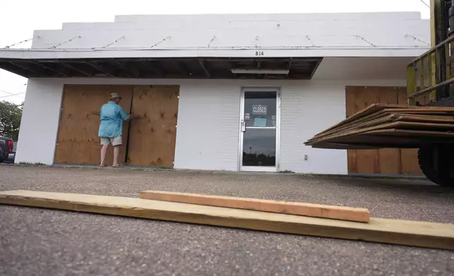 Jimmy May boards windows as he prepares for Beryl's arrival, Sunday, July 7, 2024, in Port Lavaca, Texas. Beryl is hurtling across the warm waters of the Gulf of Mexico on a collision course with Texas. (AP Photo/Eric Gay)