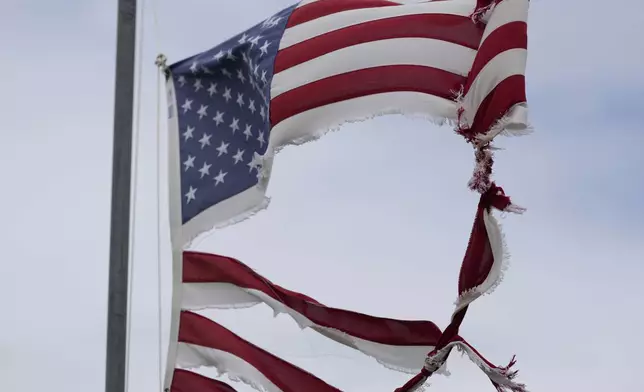 A tattered flag tips in the wind after Beryl moved through the area, Monday, July 8, 2024, in Matagorda, Texas. The National Hurricane Center said damaging winds and flash flooding will continue as Beryl continues pushing inland. (AP Photo/Eric Gay)