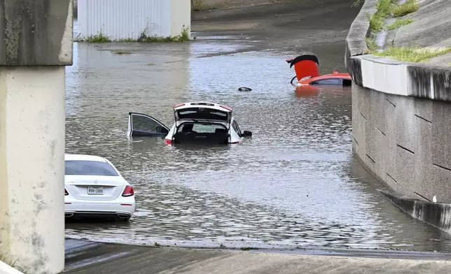 Buffalo Bayou floods stranding vehicles near Downtown Houston after Beryl came ashore in Texas as a hurricane and dumped heavy rains downtown. (AP Photo/Maria Lysaker)