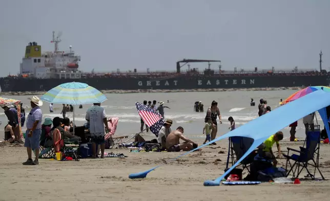 An oil taker heads out and visitors crowd the beaches in Port Aransas, Texas, ahead of Hurricane Beryl's arrival, Saturday, July 6, 2024. (AP Photo/Eric Gay)