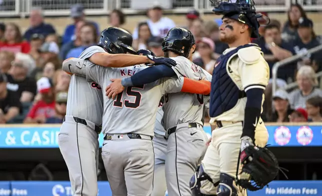 Detroit Tigers' Carson Kelly (15) celebrates with his teammates after hitting a grand slam home run as Minnesota Twins catcher Christian Vazquez, right, looks on during the third inning of a baseball game Wednesday, July 3, 2024, in Minneapolis. Riley Greene, Colt Keith and Matt Vierling also scored. (AP Photo/Craig Lassig)