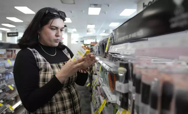 Daniella López White, of Hawaii, shops in the makeup and skincare isle of a CVS Pharmacy, Tuesday, May 14, 2024, in Boston. López White, who graduated from Emerson College in Boston this month and is on a tight budget, said TikTok influencers have helped her with tips on how to find affordable clothes at places like H&amp;M and thrift shops. She buys makeup brands at CVS based on influencer advice. (AP Photo/Steven Senne)