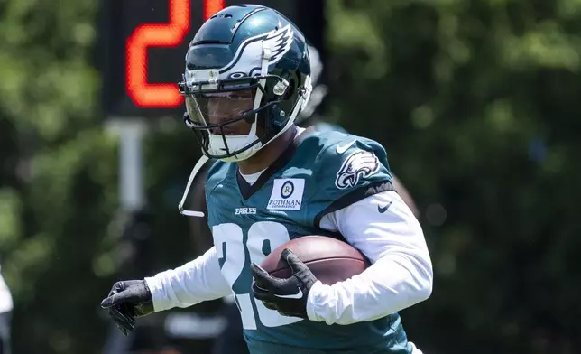 FILE - Philadelphia Eagles running back Saquon Barkley runs with the ball during practice at the NFL football team's minicamp, Tuesday, June 4, 2024, in Philadelphia. (AP Photo/Chris Szagola, File)