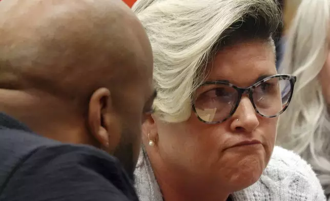 Jessica Norton, parent of a transgender student and volleyball player formerly of Monarch High School, talks with her legal council Jason Starr, left, during a Broward County School Board meeting about her daughter at Plantation High School, Tuesday, July 23, 2024. The board delayed voting on the mother's school district employment status for another week. (Joe Cavaretta/South Florida Sun-Sentinel via AP)