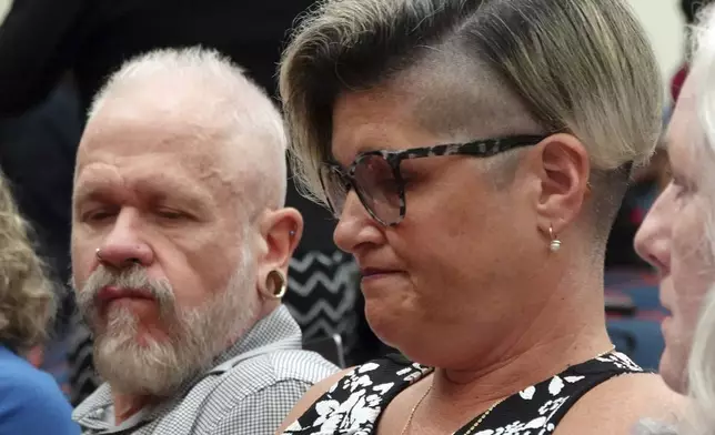 Jessica and Gary Norton, parents of a transgender student and volleyball player formerly of Monarch High School, react as the Broward County School Board discusses their daughter, during a meeting at Plantation High School, Tuesday, July 23, 2024. The board delayed voting on the mother's school district employment status for another week. (Joe Cavaretta/South Florida Sun-Sentinel via AP)