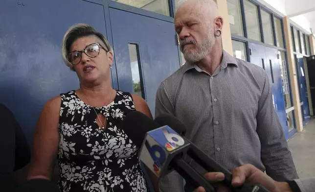 Jessica and Gary Norton, parents of a transgender student and volleyball player formerly of Monarch High School, speak to the media after the Broward County School Board meeting at Plantation High School, Tuesday, July 23, 2024. The board delayed voting on the mother's school district employment status for another week. (Joe Cavaretta/South Florida Sun-Sentinel via AP)