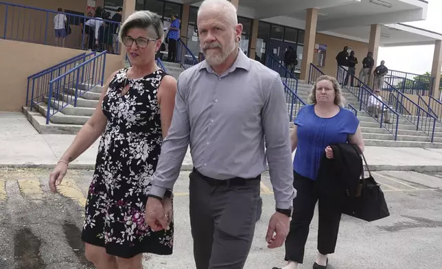 Jessica and Gary Norton, parents of a transgender student and volleyball player formerly of Monarch High School, leave a Broward County School Board meeting at Plantation High School, Tuesday, July 23, 2024. The board delayed voting on the mother's school district employment status for another week. (Joe Cavaretta/South Florida Sun-Sentinel via AP)